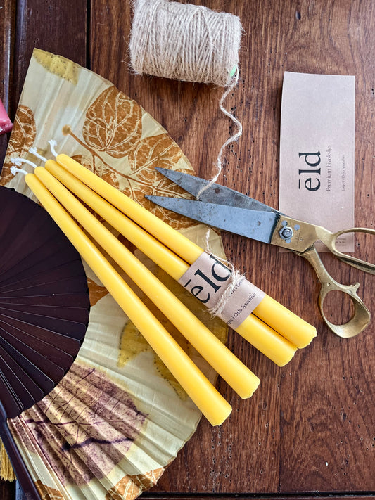 Bivoks kronelys i naturlig gul honningfarge som ligger på et bord.