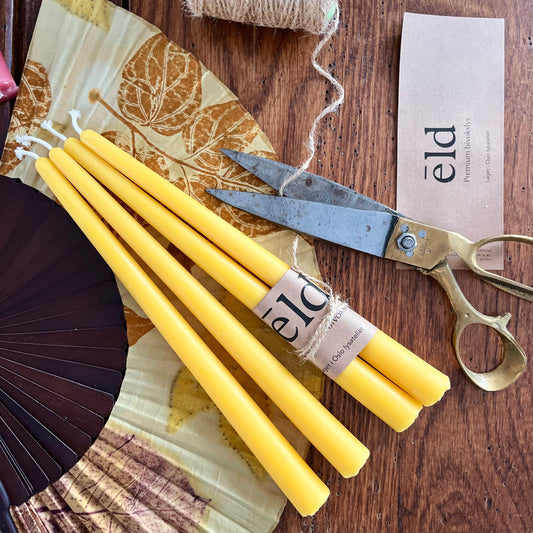 Bivoks kronelys i naturlig gul honningfarge som ligger på et bord.