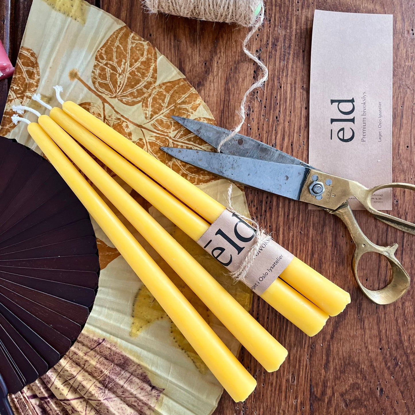 Bivoks kronelys i naturlig gul honningfarge som ligger på et bord.