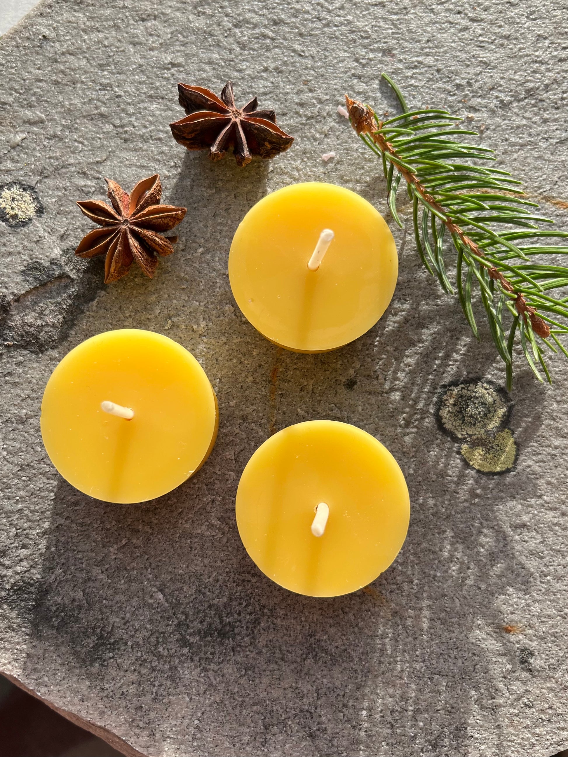 Tre bivoks telys i fargen honning. 