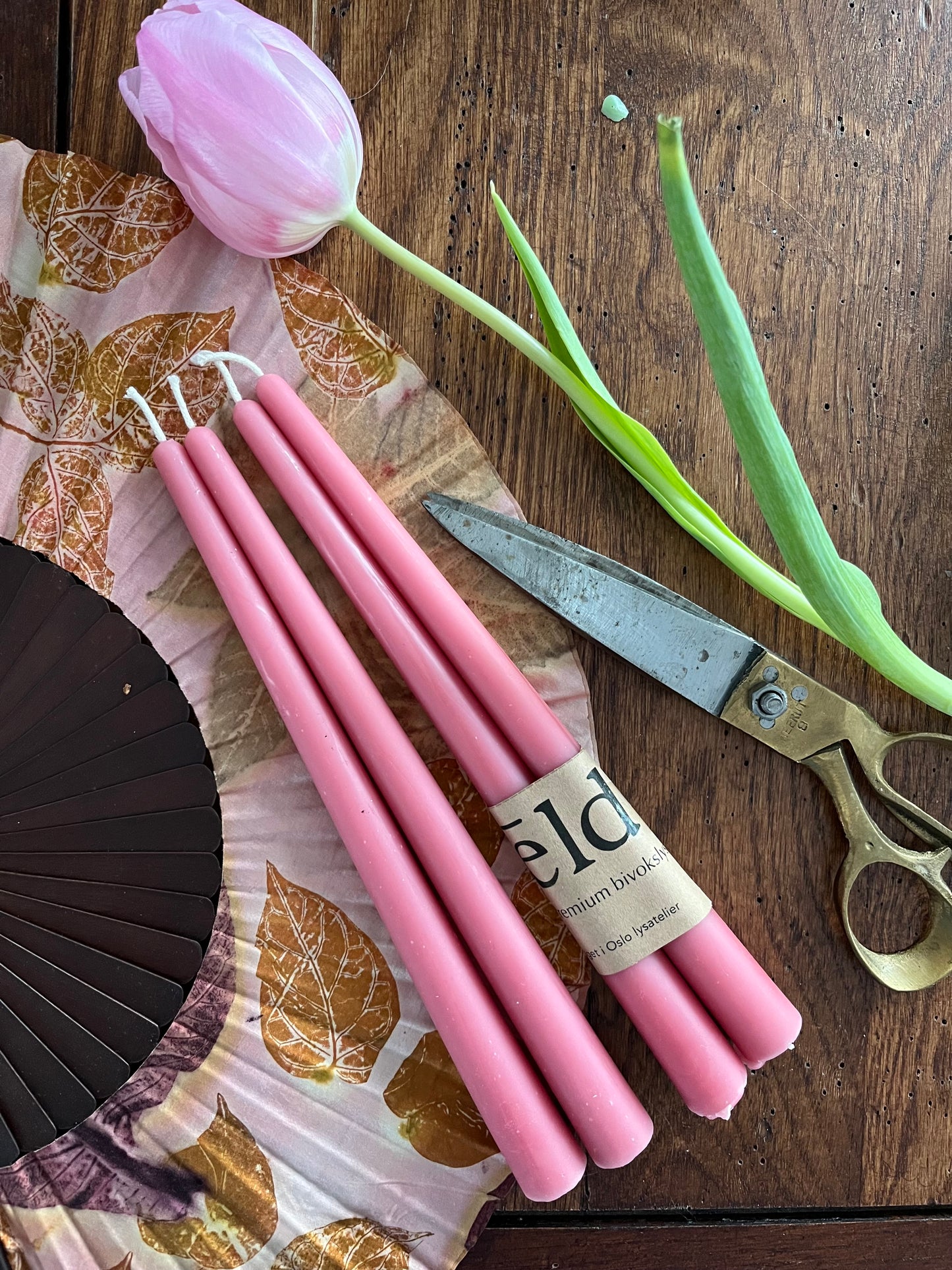 Bivoks kronelys i fargen rosegull som ligger på et bord. 